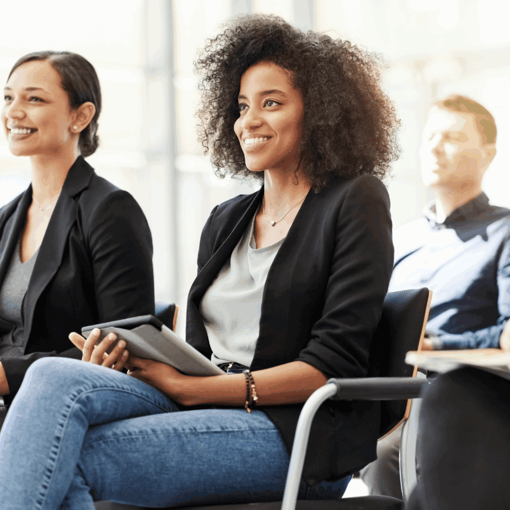 Diverse group of people smiling during a real estate investment seminar.