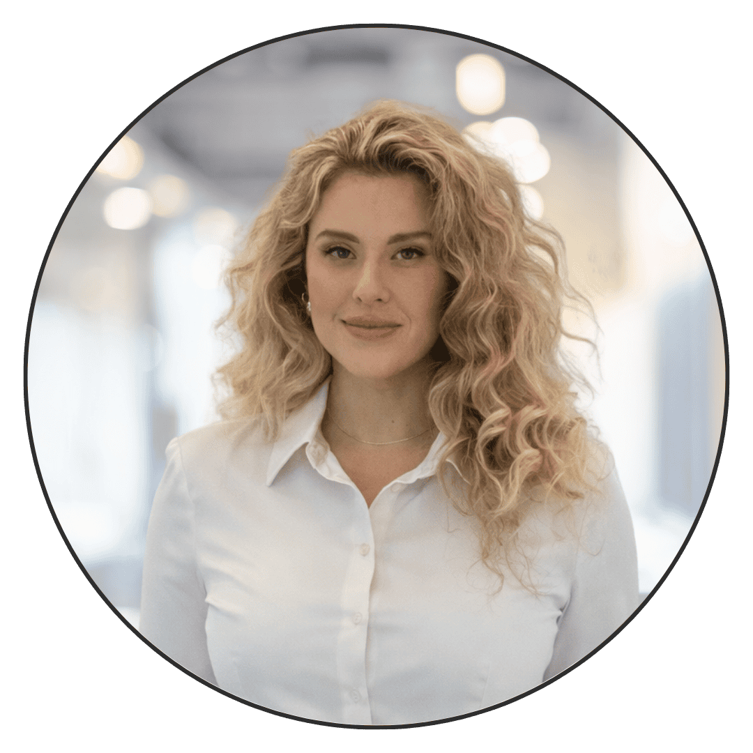 Confident woman with curly blonde hair in a modern office environment.